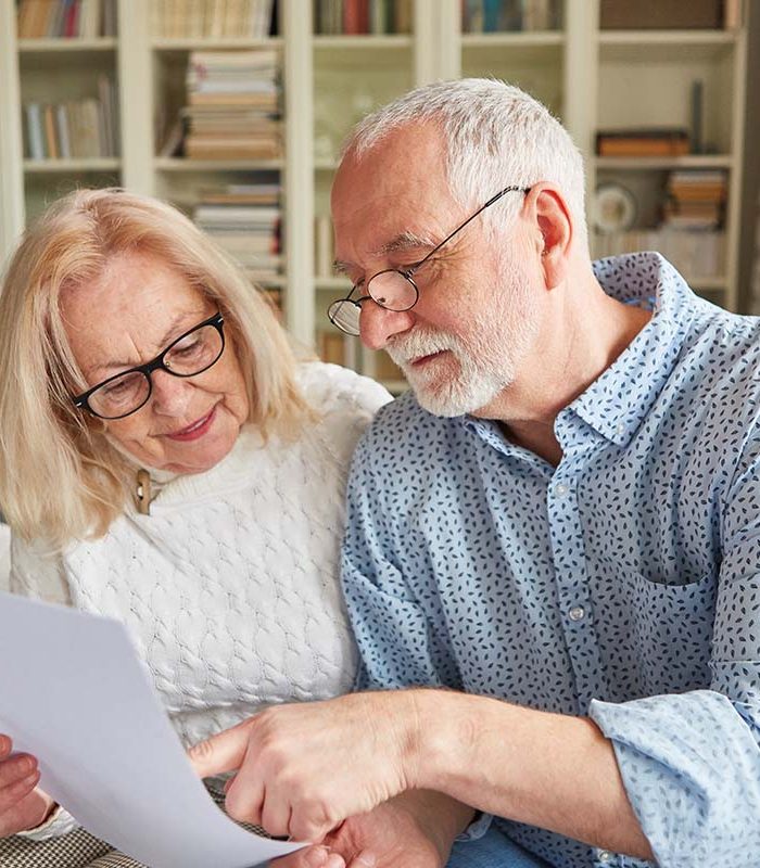 Senior couple reading a retirement plan or power of attorney or living will